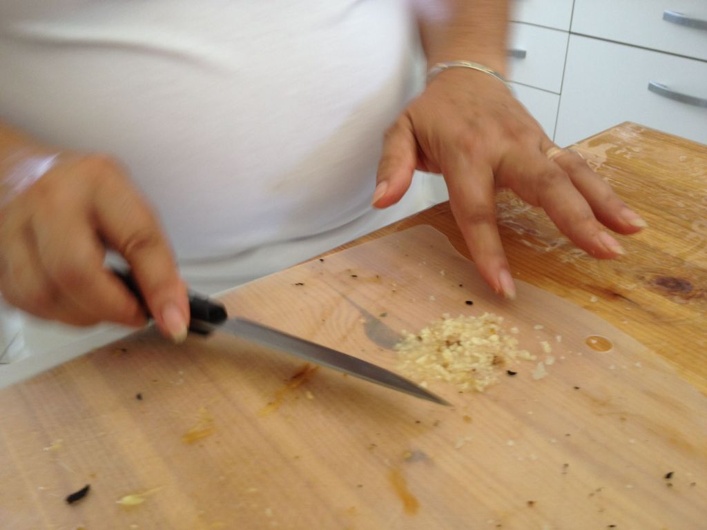 Mincing garlic with salt creates a smooth, mashed paste (photo credit: Jessica Steinberg/Times of Israel)