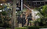 Soldiers from the Kenya Defense Forces carry a wounded colleague, following the sound of explosions and gunfire, out of the Westgate Mall in Nairobi, Kenya, on Sunday, September 22, 2013 (photo credit: AP/Ben Curtis)