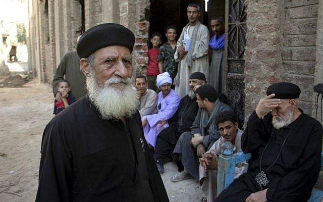 Egyptian priests gather with villagers at the door of the main church inside the Virgin Mary and St. Abraam Monastery that was looted and burned by Islamists, in Dalga, Minya province, Egypt. (AP Photo/El Shorouk Newspaper, Roger Anis)