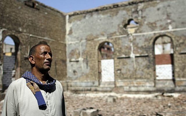 A guard looks at the ruins of the Evangelical Church of Malawi that was looted and burned by Islamists in Malawi, Minya province, Egypt. (AP Photo/El Shorouk Newspaper, Roger Anis)