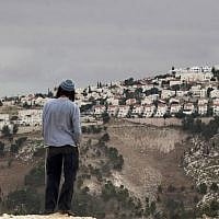 File: An Israeli settler looks at the West Bank settlement of Ma'ale Adumim from the E1 area on the eastern outskirts of Jerusalem. (AP/Sebastian Scheiner)