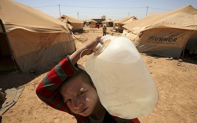 A Syrian boy carries a water jug to his family's tent at the Zaatari Refugee Camp, in Mafraq, Jordan (photo credit: AP/Mohammad Hannon/File) A Syrian boy carries a water jug to his family's tent at the Zaatari Refugee Camp, in Mafraq, Jordan (photo credit: AP/Mohammad Hannon/File)