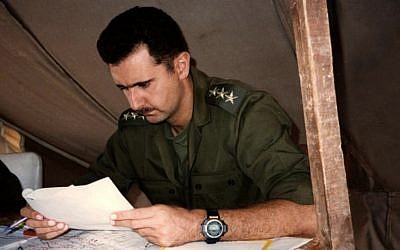 This 1994 photo posted on the official Facebook page of the Syrian Presidency, purports to show then-captain Bashar Assad, looking at documents during a military project in Syria (photo credit: AP/Syrian Presidency via Facebook)