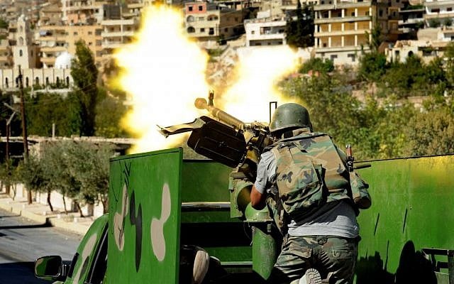 A Syrian solider fires a heavy machine gun during clashes with rebels in Maaloula village, northeast of the capital Damascus in 2013. (photo credit: AP/SANA) A Syrian solider fires a heavy machine gun during clashes with rebels in Maaloula village, northeast of the capital Damascus in 2013. (photo credit: AP/SANA)