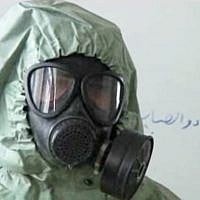 This image made from a video posted on September 18, 2013, shows a student wearing a gas mask and protective suit during a classroom session on how to respond to a chemical weapons attack in Aleppo, Syria. (photo credit: AP)