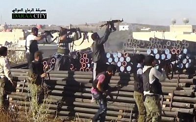 In this image taken from Wednesday, Sept. 25, 2013, video obtained from the Sham News Network, Syrian opposition fighters fire at government forces near Daraa customs in Daraa al-Balad, Syria. (Photo credit:AP/Sham News Network via AP video)