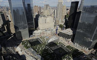 In this photo taken Thursday, Sept. 5, 2013, the wedge-shaped pavilion entrance of the National September 11 Museum, center, is located between the square outlines of the memorial waterfalls at the World Trade Center in New York. (photo credit: AP Photo/Mark Lennihan)