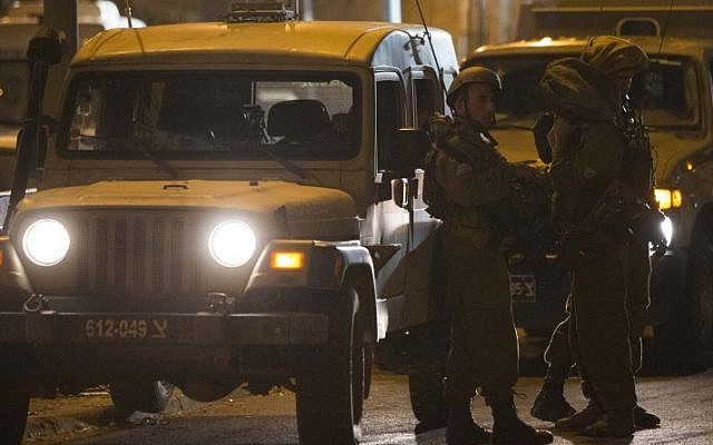 IDF soldiers stand near a shooting scene in the city of Hebron on September 22, 2013 (photo credit: Yonatan Sindel/Flash90)