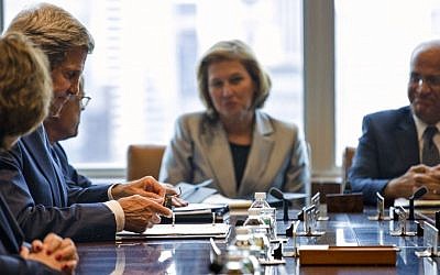 US Secretary of State John Kerry, left, prepares for the Quartet Meeting on Middle East affairs at the 68th session of the United Nations General Assembly at United Nations headquarters Friday, Sept. 27, 2013. In background is Justice Minister Tzipi Livni and Palestinian Representative Saeb Erekat. (photo credit: AP /Craig Ruttle)