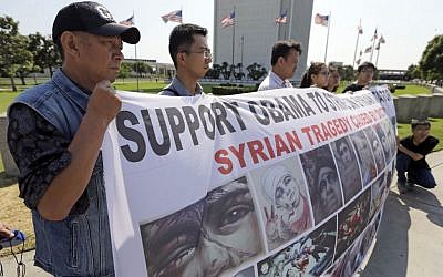 Demonstrators in favor of a US Senate resolution that would authorize President Barack Obama to use military force against the ruling regime in Syria, Tuesday, Sept. 10, 2013. (photo credit: AP/Reed Saxon)