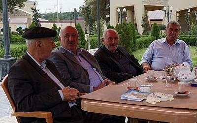 Yedidia Yehuda, right, sitting with Jewish lawmaker Yevda Abramov, second from left, in a Jewish tea house in Krasnaiya Sloboda, Aug. 22, 2013. (photo credit: Cnaan Liphshiz/JTA)