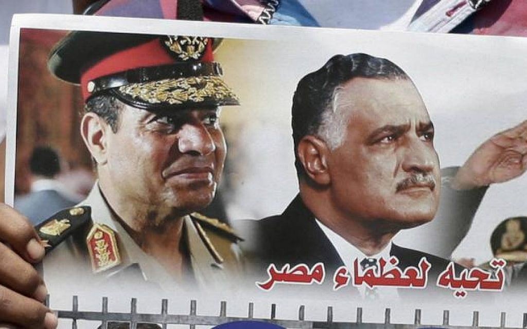 In this July 12, 2013, photo, Egyptian policemen hold a picture with portraits of Army Chief Gen. Abdel Fattah el-Sissi and former Egyptian president Gamal Abdel Nasser at Tahrir Square, in Cairo. Arabic in the picture reads,'Salutation to the great men of Egypt,' (photo credit: AP) In this July 12, 2013, photo, Egyptian policemen hold a picture with portraits of Army Chief Gen. Abdel Fattah el-Sissi and former Egyptian president Gamal Abdel Nasser at Tahrir Square, in Cairo. Arabic in the picture reads,'Salutation to the great men of Egypt,' (photo credit: AP)