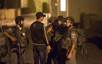 Israeli soldiers speak with a local resident near a shooting scene in the city of Hebron on September 22, 2013 (photo credit: Yonatan Sindel/Flash90)
