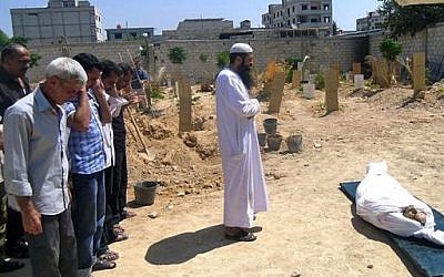 Syrians pray during the funeral of a man killed by a shell in Arbeen town, a suburb of Damascus, Syria, Tuesday, Sept. 3, 2013 (photo credit: AP/United media office of Arbeen)