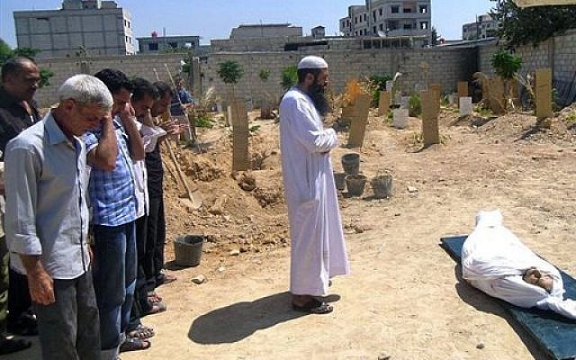 Syrians pray during the funeral of a man killed by a shell in Arbeen town, a suburb of Damascus, Syria, Tuesday, Sept. 3, 2013 (photo credit: AP/United media office of Arbeen) Syrians pray during the funeral of a man killed by a shell in Arbeen town, a suburb of Damascus, Syria, Tuesday, Sept. 3, 2013 (photo credit: AP/United media office of Arbeen)