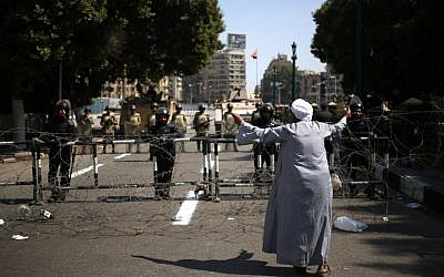 An Egyptian man gestures to Egyptian Army soldiers standing guard at an entrance to Tahrir Square, in Cairo, Egypt, on Sunday, October 6, 2013. (photo credit: AP/Khalil Hamra)
