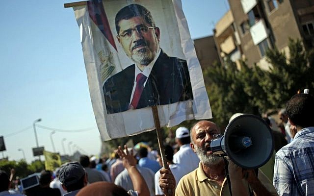 Supporters of Egypt's ousted president Mohammed Morsi (seen on a poster) chant slogans against Egyptian Defense Minister Gen. Abdel-Fattah el-Sissi, during a protest in Cairo (photo credit: AP/Khalil Hamra) Supporters of Egypt's ousted president Mohammed Morsi (seen on a poster) chant slogans against Egyptian Defense Minister Gen. Abdel-Fattah el-Sissi, during a protest in Cairo (photo credit: AP/Khalil Hamra)
