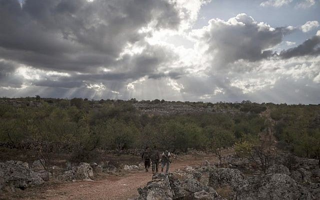 Ahmed Kale, right, walks with his men on the outskirts of Kfar Lata. (photo credit: AP Photo)