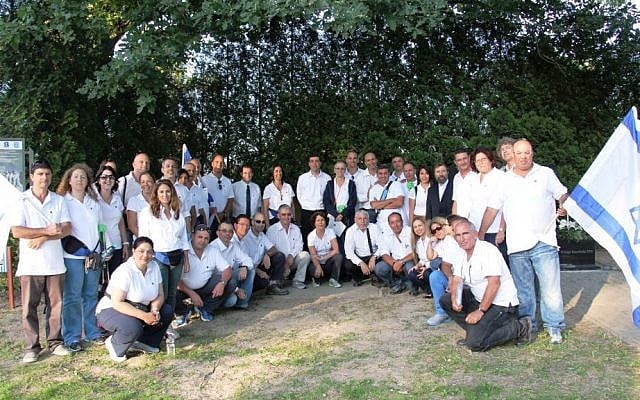 Yaki Gantz (kneeling, far right) and a Bezeq-sponsored delegation at a ceremony in Poland in July to dedicate a new gravemarker for Jews killed in the Holocaust who were buried in Christian graves. (photo credit: Nissan Tsur)