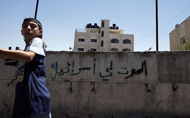 A Palestinian boy walks past a wall painted with graffiti reading 'Death to Israel' in the northern Jerusalem Palestinian neighborhood of Beit Hanina, July 2008 (Michal Fattal/Flash90) A Palestinian boy walks past a wall painted with graffiti reading 'Death to Israel' in the northern Jerusalem Palestinian neighborhood of Beit Hanina, July 2008 (Michal Fattal/Flash90)