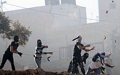 Palestinians throw rocks near Ramallah on October 12, 2013 (Illustrative photo: Issam Rimawi/Flash90)