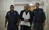 A man is escort by police at Jerusalem District Court after being sentenced to prison as the head of sadistic cult on October 17, 2013. (photo credit: Yonatan Sindel/Flash90)
