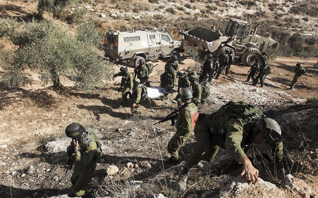 IDF soldiers carry away the body of armed Palestinian terror suspect Mohamed Aazi near the West Bank village of Bil'in, near Ramallah October 22, 2013. (Photo credit: Issam Rimawi /FLASH90) IDF soldiers carry away the body of armed Palestinian terror suspect Mohamed Aazi near the West Bank village of Bil'in, near Ramallah October 22, 2013. (Photo credit: Issam Rimawi /FLASH90)