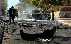 A bomb squad investigates the charred remains of a car after a powerful explosion in the coastal city of Ashkelon on Thursday afternoon. Two men were seriously injured in the blast, and one later died of his wounds while hospitalized. (photo credit: Edi Israel/Flash90)