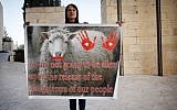 A woman holds a sign against the release Tuesday October 29, 2013 of Palestinian prisoners outside of the High Court in Jerusalem. (Photo credit: Flash90)