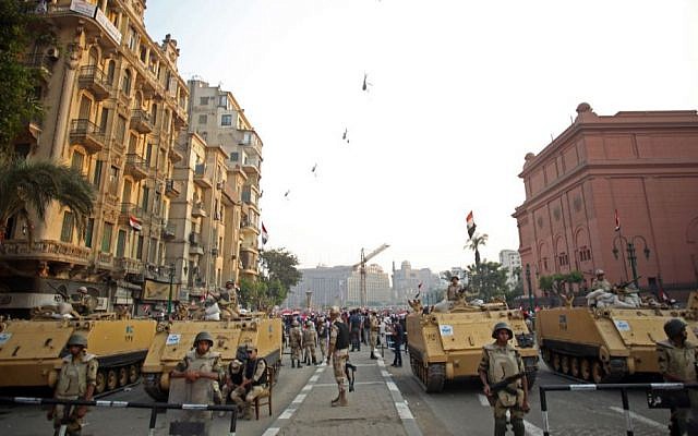 Egyptian military helicopters fly overhead as soldiers stand guard at an entrance to Tahrir Square, in Cairo, Egypt, Oct. 6, 2013 (photo credit: AP/Khalil Hamra/File) Egyptian military helicopters fly overhead as soldiers stand guard at an entrance to Tahrir Square, in Cairo, Egypt, Oct. 6, 2013 (photo credit: AP/Khalil Hamra/File)