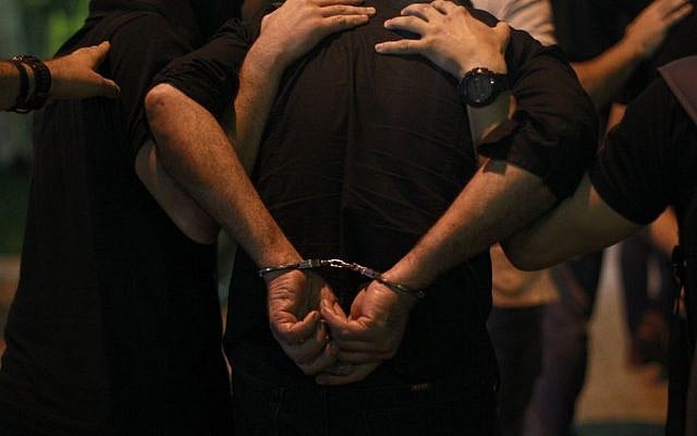 Anti-terror police officers escort a handcuffed suspect, member of the extreme far-right Golden Dawn party, at the court in Athens, Saturday, September 28, 2013 (photo credit: AP Photo/Kostas Tsironis)