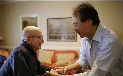 Cellist Yo-Yo Ma, right, greets Holocaust survivor George Horner in a rehearsal room at Symphony Hall Tuesday afternoon, Oct. 22, 2013, in Boston. (photo credit: AP Photo/Steven Senne)