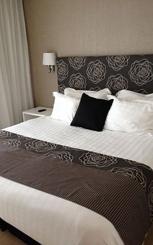 Crisp bedding, plenty of pillows and the sounds of the sea outside at the Tamares West Hotel (photo credit: Jessica Steinberg/Times of Israel)