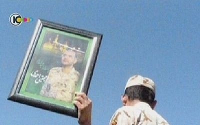 A mourner holds a photo of the late Iranian cyber war operative Mojtaba Ahmadi. Reports that he was assassinated were denied by the Iranian Revolutionary Guard who said he died in a ‘horrific incident.’ (Screenshot/Channel 10)