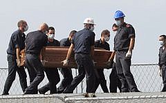 The casket of one of the migrants who died when their boat capsized off in the Canal of Sicily is carried aboard a Italian Navy ship at the Lampedusa island harbor, Saturday, Oct. 12, 2013 (photo credit: AP/Amedeo Fragapane)
