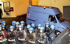 A van allegedly carrying the coffin of Nazi war criminal Erich Priebke is protected by policemen in riot gear as it leaves the Society of St. Pius X headquarters, a schismatic Catholic group, where his funeral was scheduled to take place in Albano Laziale, on the outskirts of Rome on Tuesday, October 15, 2013. (photo credit: AP/Riccardo De Luca)