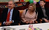 Prime Minister Benjamin Netanyahu sits with his wife Sara and son Yair at his 64th birthday party at the Prime Minister's Office in 2013. (photo credit: Kobi Gideon/GPO)