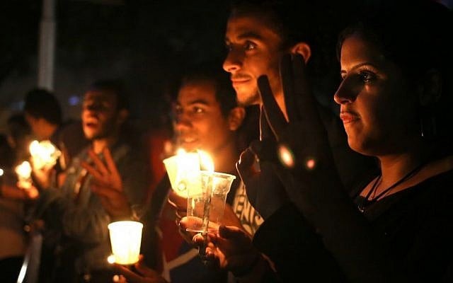 Protesters in Cairo hold candles during a vigil on Wednesday marking the second anniversary of a military crackdown on protesters outside Egypt's state TV building, which resulted in 26 deaths. (photo credit: AP/Khalil Hamra) Protesters in Cairo hold candles during a vigil on Wednesday marking the second anniversary of a military crackdown on protesters outside Egypt's state TV building, which resulted in 26 deaths. (photo credit: AP/Khalil Hamra)