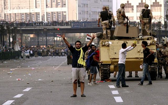 A supporter of ousted Egyptian President Mohammed Morsi raises his hands with a gesture of an open palm with four raised fingers that has became a symbol for the Rabaah al-Adawiya mosque where hundreds of Muslim Brotherhood supporters were killed by security forces in August, in Ramsis Square, Cairo, Egypt (photo credit: AP) A supporter of ousted Egyptian President Mohammed Morsi raises his hands with a gesture of an open palm with four raised fingers that has became a symbol for the Rabaah al-Adawiya mosque where hundreds of Muslim Brotherhood supporters were killed by security forces in August, in Ramsis Square, Cairo, Egypt (photo credit: AP)