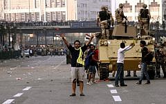 A supporter of ousted Egyptian President Mohammed Morsi raises his hands with a gesture of an open palm with four raised fingers that has became a symbol for the Rabaah al-Adawiya mosque where hundreds of Muslim Brotherhood supporters were killed by security forces in August, in Ramsis Square, Cairo, Egypt. (Photo credit: AP/Sabry Khaled, El-Shorouk Newspaper)