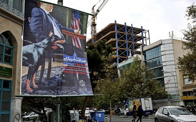 A poster depicting an American negotiator wearing a suit jacket and tie at a negotiating table and a dog to his side is displayed in Palestine square, Tehran, Iran, Sunday, Oct. 27, 2013. (Photo credit: AP/Ebrahim Noroozi) A poster depicting an American negotiator wearing a suit jacket and tie at a negotiating table and a dog to his side is displayed in Palestine square, Tehran, Iran, Sunday, Oct. 27, 2013. (Photo credit: AP/Ebrahim Noroozi)