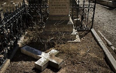In this Monday, Oct. 7, 2013 photo, a damaged grave after a vandal attack is shown in the Protestant Cemetery of Mt. Zion, Jerusalem. (Photo credit: AP/Bernat Armangue)