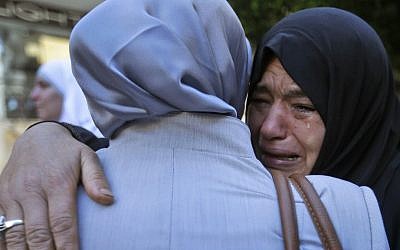 A Syrian refugee in Beirut says goodbye to a relative at the International Organization for Migration office before some refugees board a bus to Beirut International Airport for a flight to Germany, after being accepted for temporary resettlement. (AP/Hussein Malla)
