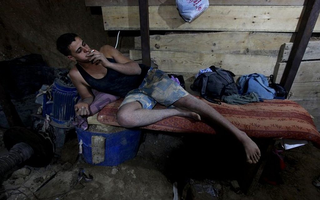 Smoking in a smuggling tunnel connecting Gaza and Egypt (photo credit: Hatem Moussa/AP) Smoking in a smuggling tunnel connecting Gaza and Egypt (photo credit: Hatem Moussa/AP)
