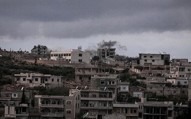 Smoke rises after a mortar shell hits a rebel position during clashes in Kfar Lata, a ghost village at the top of a mountain subdued under heavy shelling and bombardments due the fighting between opposition fighters and government forces in the Idlib province countryside of Syria, on Thursday, October 3, 2013. (photo credit: AP photo) Smoke rises after a mortar shell hits a rebel position during clashes in Kfar Lata, a ghost village at the top of a mountain subdued under heavy shelling and bombardments due the fighting between opposition fighters and government forces in the Idlib province countryside of Syria, on Thursday, October 3, 2013. (photo credit: AP photo)