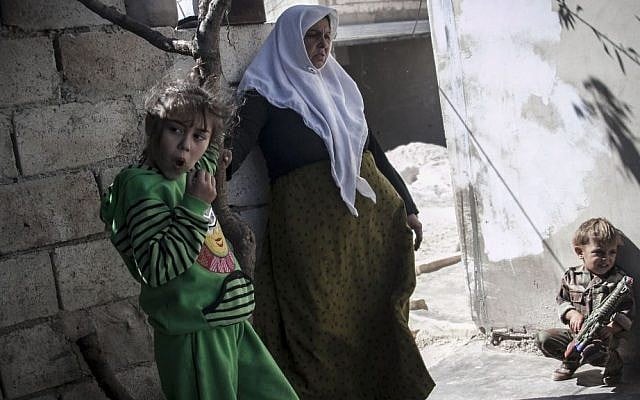 The wife of Mohammed Kale stands with her granddaughter and grandson in the yard of her family house in Kfar Lata, on Thursday, October 3, 2013. (photo credit: AP Photo) The wife of Mohammed Kale stands with her granddaughter and grandson in the yard of her family house in Kfar Lata, on Thursday, October 3, 2013. (photo credit: AP Photo)