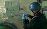 Video broadcast on Syrian State Television purports to show an UN expert examining a chemical weapons plant at an unknown location in Syria, October 8, 2013 (AP/Syrian State Television)
