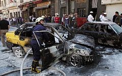 Firefighters extinguish a burning vehicle after two mortar rounds struck the Abu Roumaneh area in Damascus, Syria, Saturday, Oct. 12, 2013. (Photo credit: AP)
