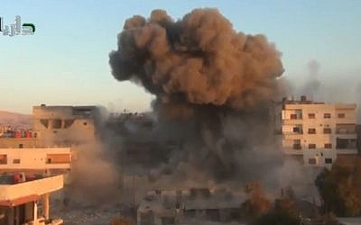 Illustrative photo of smoke billowing amid buildings in Daraya, near Damascus, Syria, on Tuesday, October 15, 2013. (photo credit: AP/Shaam News Network via AP Video)