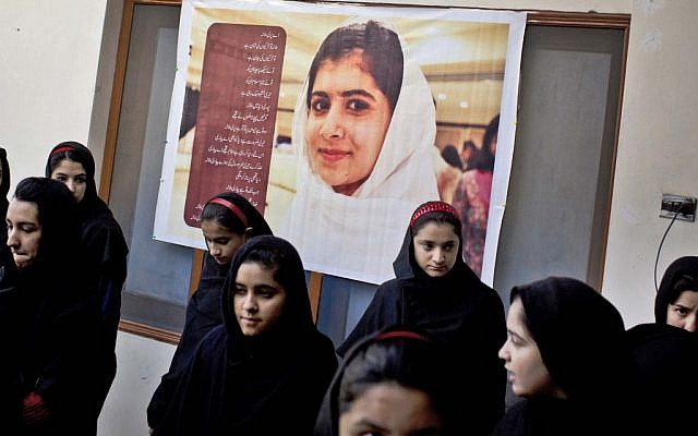 In this Thursday, November 15, 2012 photo, Pakistani girls gather under a poster of Malala Yousufzai in her old school in Mingora, Swat Valley, Pakistan. The giant poster of her that once emblazoned the wall of the assembly hall has since been removed. (photo credit: AP Photo/Anja Niedringhaus) In this Thursday, November 15, 2012 photo, Pakistani girls gather under a poster of Malala Yousufzai in her old school in Mingora, Swat Valley, Pakistan. The giant poster of her that once emblazoned the wall of the assembly hall has since been removed. (photo credit: AP Photo/Anja Niedringhaus)